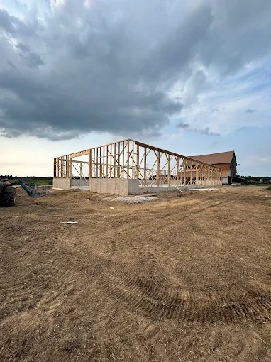 Shelvalley Carpentry post-frame building framed on-site under a dramatic Ontario sky